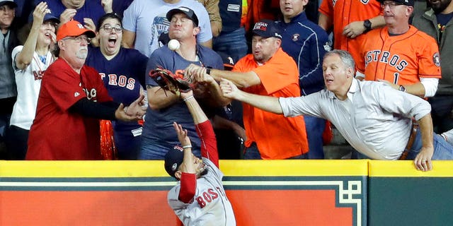 FILE: Fans interfere with Boston Red Sox right fielder Mookie Betts trying to catch a ball hit by Houston Astros' Jose Altuve.