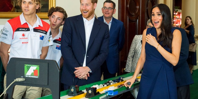 The Duke and Duchess of Sussex start model Formula 1 cars during a demonstration at a reception given by the Governor of Victoria at Government House during their visit to Melbourne, Australia, Thursday, Oct. 18, 2018. Prince Harry and his wife Meghan are on day two of their 16-day tour of Australia and the South Pacific. (Dominic Lipinski/Pool via AP)