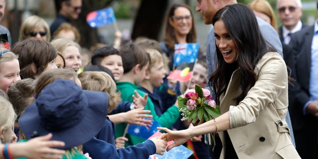 Britain's Prince Harry and Meghan, Duchess of Sussex greet children during a visit to Albert Park Primary School in Melbourne, Australia, Thursday, Oct. 18, 2018. Prince Harry and his wife Meghan are on day three of their 16-day tour of Australia and the South Pacific.(AP Photo/Kirsty Wigglesworth,Pool)