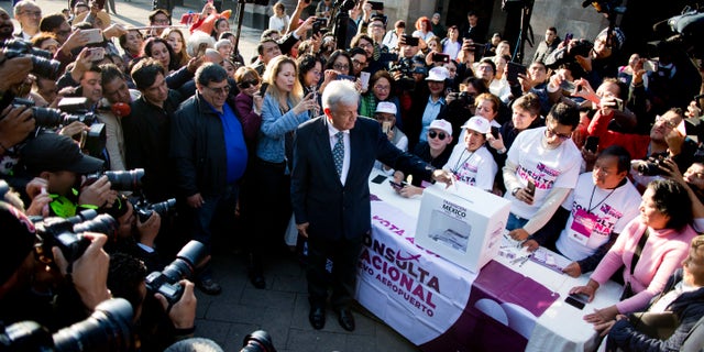 Mexico's President-elect Andres Manuel Lopez Obrador casts his vote on whether to continue with the $13 billion airport to replace the current Benito Juarez International Airport in Mexico City, Thursday, Oct. 25, 2018. The future of Mexico City's new airport, already about a third completed, comes down to a public vote this week in a political high-wire act by the country's president-elect that could shut down Mexico's largest infrastructure project in recent memory. Lopez Obrador promised to let the people decide the fate of the airport. (AP Photo/Eduardo Verdugo)