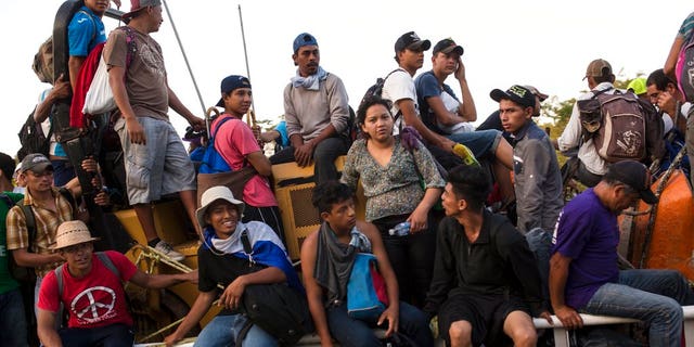 Central American migrants traveling with a caravan to the U.S. crowd onto a tractor as they make their way to Mapastepec, Mexico.