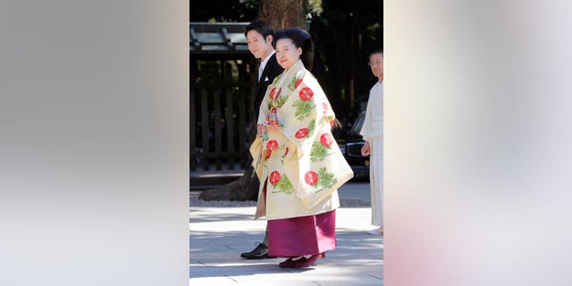 Japanese Princess Ayako, front, the third daughter of the late Prince Takamado, dressed in traditional ceremonial gown, and Japanese businessman Kei Moriya, rear, arrive at Meiji Shrine for their wedding ceremony in Tokyo, Monday, Oct. 29, 2018.(Kyodo News via AP)