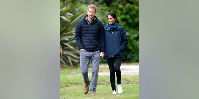 Prince Harry and Duchess Megan walk together at Abel Tasman National Park in New Zealand on Monday.
