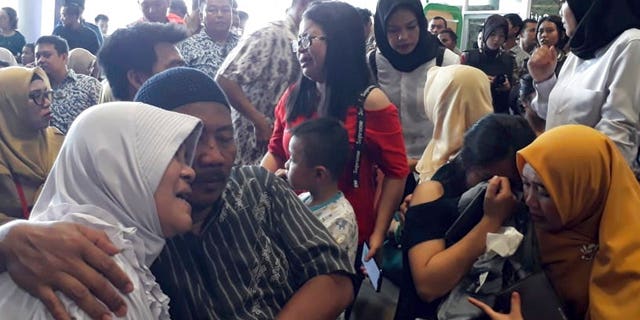 Relatives of passengers comfort each other as they wait for news on a Lion Air plane that crashed off Java Island at Depati Amir Airport in Pangkal Pinang, Indonesia.