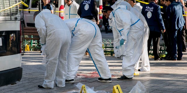 Tunisian forensic experts work on the scene of an attack after a 30-year-old woman blew herself on the Habib Bourguiba avenue in Tunis, Tunisia. (AP Photo/Riadh Dridi)