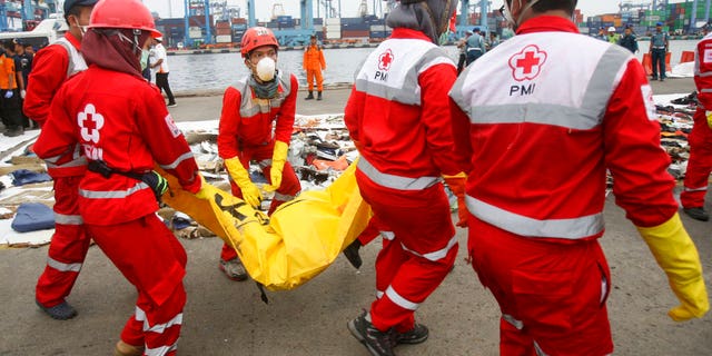Rescuers carry a body bag containing the remains of victims retrieved from the waters where Lion Air flight JT 610 is believed to have crashed at Tanjung Priok Port in Jakarta, Indonesia.