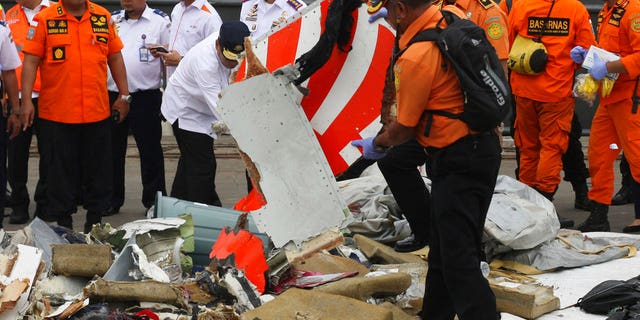 FILE: A rescuer inspects a part of Lion Air plane flight JT 610 retrieved from the waters where it's believed to have crashed at Tanjung Priok Port in Jakarta, Indonesia, Tuesday.