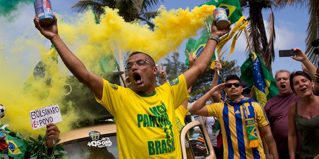 Supporters of Jair Bolsonaro singing the national anthem in front of his house during the presidential runoff election in Rio de Janeiro, Brazil, on Sunday. (AP Photo/Silvia Izquierdo)