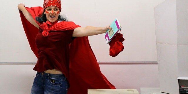 A woman donning the official Workers' Party color celebrates after voting in the presidential runoff election in Sao Paulo, Brazil, on Sunday. (AP Photo/Nelson Antoine)