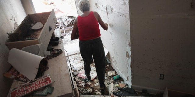 Luke Bryan's mother moves through the rubble of her home after Hurricane Michael.