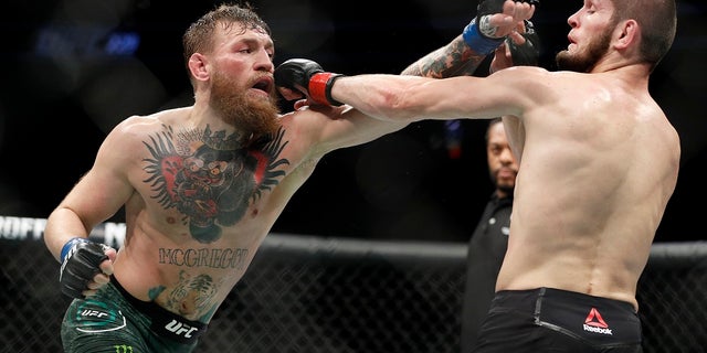 Conor McGregor, left, and Khabib Nurmagomedov throw punches during a lightweight title mixed martial arts bout at UFC 229 in Las Vegas, Saturday, Oct. 6, 2018. (AP Photo/John Locher)