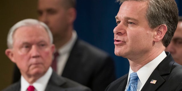 Le procureur général Jefferson Sessions III écoute le directeur du FBI, Christopher Wray, parler.