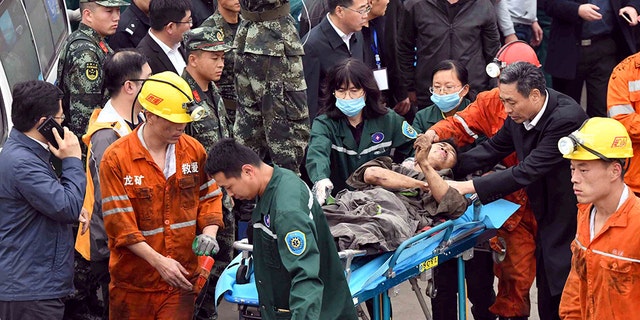 A worker is carried on a stretcher out of the Longyun coal mine in Yuncheng County, east China's Shandong Province, Sunday. (Guo Xulei/Xinhua via AP)