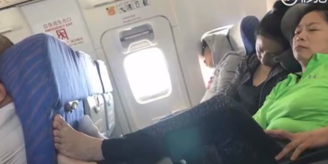 One woman travelling on a plane in China put her feet up on tray table and then refused to take them back down.