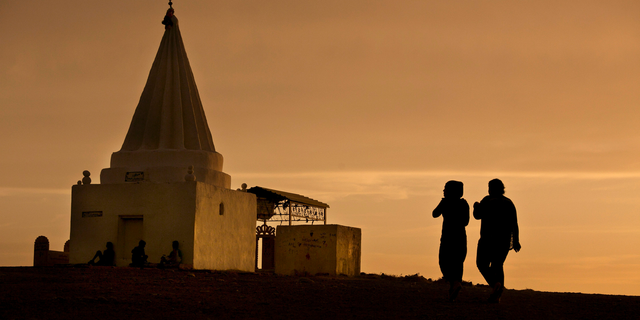 The sun sets as women visit a Yazidi shrine overlooking at Kankhe Camp for the internally displaced in Dahuk, northern Iraq, in this Wednesday, May 18, 2016 file photo. Over the past centuries, the Yazidi community, one of Iraq's oldest religious minorities, has repeatedly been subjected to brutal attacks leaving thousands of its members dead. One of their worst subjugations occurred four years ago with the rise of the extremist Islamic State group.