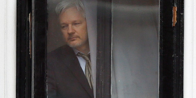 FILE - In this Feb. 5, 2016 file photo, Wikileaks founder Julian Assange walks onto the balcony of the Ecuadorean Embassy in London. An Ecuadorean judge ruled Monday, Oct. 29, 2018 against a request by him to loosen requirements he says are meant to push him out of the London embassy where he lives. (AP Photo/Kirsty Wigglesworth, File)