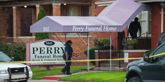 In this Friday, Oct. 19, 2018 photo, Detroit Police walk into the Perry Funeral Home in Detroit, where police removed the remains of 63 fetuses. (John T. Greilick/Detroit News via AP)