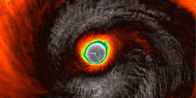 This false-color satellite image provided by the National Oceanic and Atmospheric Administration (NOAA) shows the moment the eye of Super Typhoon Yutu passed over Tinian, one of three main islands in the U.S. Commonwealth of the Northern Mariana Islands, producing damaging winds and high surf Wednesday, Oct. 24, 2018. The National Weather Service in Honolulu says maximum sustained winds of 180 mph (290 kph) were recorded around the eye of the storm, which passed over Tinian island and Saipan early Thursday morning local time. Waves of 25 to 40 feet (6 to 12 meters) are expected around the eye of the storm. (NOAA via AP)