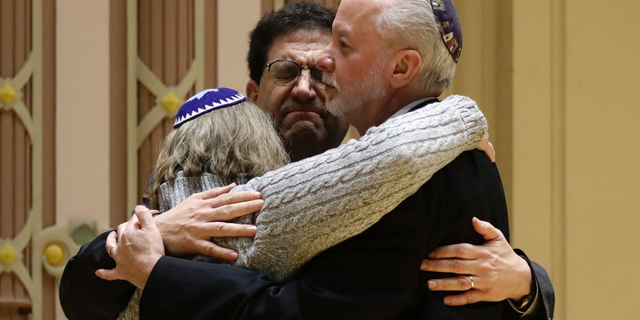 Rabbi Jeffrey Myers, right, of Tree of Life/Or L'Simcha Congregation hugs Rabbi Cheryl Klein, left, of Dor Hadash Congregation and Rabbi Jonathan Perlman during a community gathering held in the aftermath of a deadly shooting at the Tree of Life Synagogue in Pittsburgh, Sunday, Oct. 28, 2018. (AP Photo/Matt Rourke)