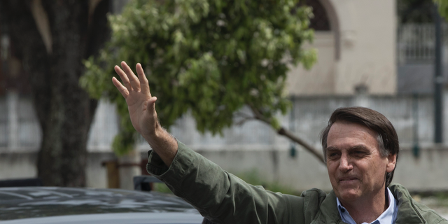 Presidential candidate Jair Bolsonaro, of the far-right Social Liberal Party waves to supporters after voting at a polling station in Rio de Janeiro, Brazil, Sunday, Oct. 28, 2018. Bolsonaro is running against leftist candidate Fernando Haddad of the Workers' Party. (AP Photo/Leo Correa)