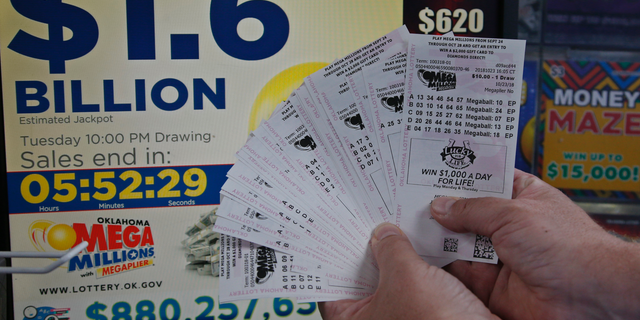 A customer, who did not want to be identified, displays the $200.00 worth of Mega Millions tickets he bought at Downtown Plaza convenience store in Oklahoma City, Tuesday, Oct. 23, 2018. (AP Photo/Sue Ogrocki)