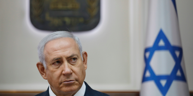 FILE -In this Oct. 7, 2018 file photo, Israel Prime Minister Benjamin Netanyahu attends the weekly cabinet meeting at his office in Jerusalem. On Sunday, Oct, 21, 2018, Netanyahu postponed the planned demolition of a West Bank hamlet to allow time for a negotiated solution with its residents. Israel has come under heavy criticism, with major European countries urging it to avoid the demolition of Khan al-Ahmar. The International Criminal Court's chief prosecutor recently said such a move could constitute a war crime. (Abir Sultan/Pool via AP, File)