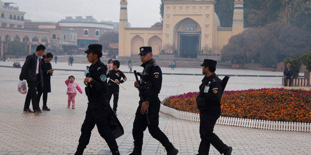In this Nov. 4, 2017 file photo, Uighur security personnel patrol near the Id Kah Mosque in Kashgar in western China's Xinjiang region. China's northwestern region of Xinjiang has revised legislation to allow the detention of suspected extremists in "education and training centers." (AP Photo/Ng Han Guan, File)