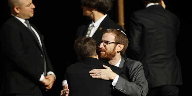 Mourners hug outside Rodef Shalom Congregation during the funeral services for brothers Cecil and David Rosenthal, Tuesday, Oct. 30, 2018, in Pittsburgh. The brothers were killed in the mass shooting Saturday at the Tree of Life synagogue. (AP Photo/Matt Rourke)