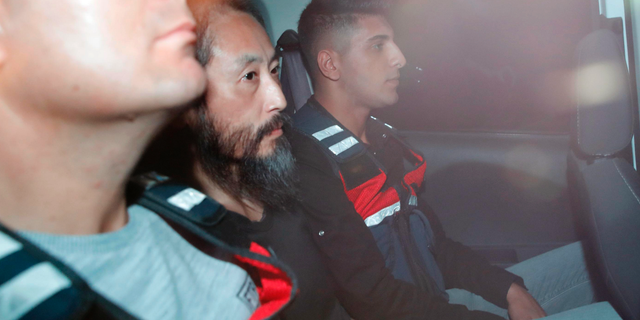 Japanese journalist Jumpei Yasuda, center, is driven out of the immigration center in Antakya, Turkey, Wednesday, Oct. 24, 2018. Yasuda was freed after more than three years of captivity in Syria Wednesday. (Yosuke Mizuno/Kyodo News via AP)