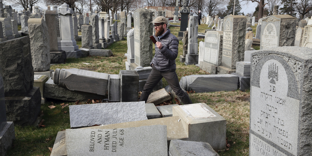 FILE - In this Feb. 27, 2017, file photo, Rabbi Joshua Bolton of the University of Pennsylvania's Hillel center surveys damaged headstones at Mount Carmel Cemetery in Philadelphia. The shooting rampage that killed more than 10 people at Pittsburgh's Tree of Life Synagogue on Saturday, Oct. 27, 2018, is being decried as the deadliest attack on Jews in U.S. history. Yet the carnage, however unprecedented, is not an aberration: Year after year, decade after decade, anti-Semitism proves to be among the most entrenched and pervasive forms of hatred and bigotry in the United States. (AP Photo/Jacqueline Larma, File)