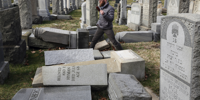 FILE - In this Feb. 27, 2017, file photo, Rabbi Joshua Bolton of the University of Pennsylvania's Hillel center surveys damaged headstones at Mount Carmel Cemetery in Philadelphia. The shooting rampage that killed more than 10 people at Pittsburgh's Tree of Life Synagogue on Saturday, Oct. 27, 2018, is being decried as the deadliest attack on Jews in U.S. history. Yet the carnage, however unprecedented, is not an aberration: Year after year, decade after decade, anti-Semitism proves to be among the most entrenched and pervasive forms of hatred and bigotry in the United States. (AP Photo/Jacqueline Larma, File)