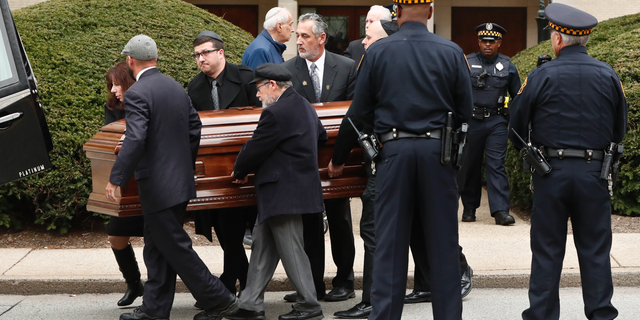 Pittsburgh police stand guard as pallbearers carry the casket of Irving Younger, 69, from Congregation Rodef Shalom after his funeral on Wednesday, Oct. 31, 2018, in Pittsburgh. Younger was one of the eleven victims killed in the deadly shooting at a synagogue in Pittsburgh's Squirrel Hill neighborhood on Saturday. (AP Photo/Keith Srakocic)