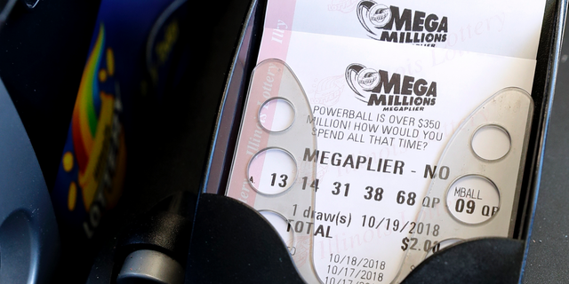 Mega Millions lottery tickets are printed out of a lottery machine at a convenience store Wednesday, Oct. 17, 2018, in Chicago. The estimated jackpot for Friday's drawing would be the second-largest lottery prize in U.S. history with a jackpot estimated to exceed $900 million. (AP Photo/Nam Y. Huh)