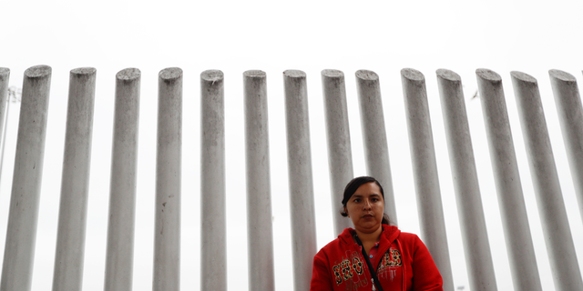 In this Oct. 23, 2018 image, Ana Delia Soto Duarte, who seeks asylum in the United States from her home in Guerrero, Mexico, waits in hopes of hearing her number called to cross the border in Tijuana, Mexico.