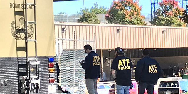 Agents of the Bureau of Alcohol, Tobacco and Firearms work outside a post office, Monday, Nov. 29, 2018 in Atlanta. Bomb squads were called to the post office about a suspicious parcel, just hours before a court hearing for a Florida man accused of sending packages containing explosive material to prominent Democrats. (AP Photo/Jeff Martin)