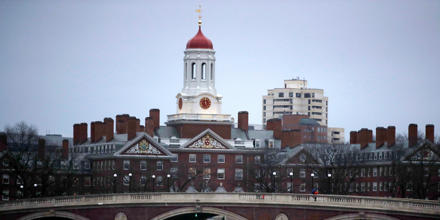 In this file photo, rowers paddle down the Charles River past the campus of Harvard University in Cambridge, Mass.
