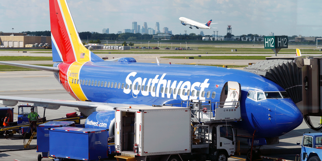 FILE- In this July 17, 2018, file photo ramp workers prepare a Southwest Airlines Boeing 737 for departure to Denver from Minneapolis International Airport in Minneapolis. Southwest Airlines Co. reports earnings Thursday, Oct. 25. (AP Photo/David Zalubowski, File)