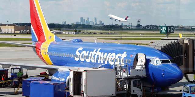 FILE- In this July 17, 2018, file photo ramp workers prepare a Southwest Airlines Boeing 737 for departure to Denver from Minneapolis International Airport in Minneapolis. Southwest Airlines Co. reports earnings Thursday, Oct. 25. (AP Photo/David Zalubowski, File)