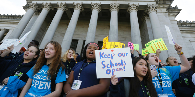 FILE - In this Feb. 25, 2016, file photo, children hold signs during a rally in support of charter schools at the Capitol in Olympia, Wash. On Thursday, Oct. 25, 2018, the Washington Supreme Court upheld most of the state's charter school law, eliminating the specter that the classrooms serving more than 3,000 students might have to close. (AP Photo/Ted S. Warren, File)