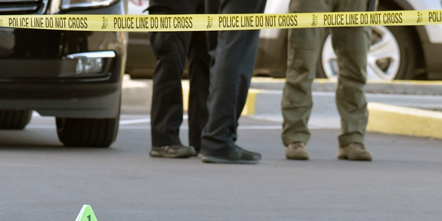 A gun lies on the ground inside a police barricade following a shooting at a Kroger grocery that left two people dead and a suspect in custody, Wednesday, Oct. 24, 2018, in Jeffersontown, Ky. A male suspect fatally shot a man and a woman at a Kroger grocery store on the outskirts of Louisville, Kentucky, and then exchanged fire with an armed bystander before fleeing the scene, police said. He was captured shortly afterward. (AP Photo/Timothy D. Easley)