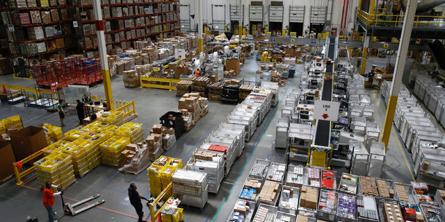 In this Aug. 3, 2017, file photo, workers prepare to move products at an Amazon fulfillment center in Baltimore. (AP Photo/Patrick Semansky)