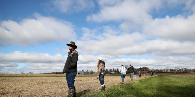 Louie Lauderdale, of Lake Geneva, Wis. searches near a cornfield along 15th Ave. near highway 25 just North of Barron, Wis., Tuesday, Oct. 23, 2018, for 13-year-old Jayme Closs, who was discovered missing Oct. 15 after her parents were found fatally shot at their home. (Jerry Holt/Star Tribune via AP)