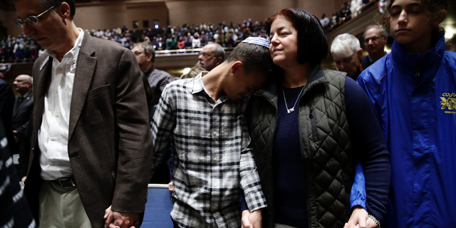People mourn in Soldiers & Sailors Memorial Hall & Museum during a community gathering held in the aftermath of Saturday's deadly shooting at the Tree of Life Synagogue in Pittsburgh, Sunday, Oct. 28, 2018. (AP Photo/Matt Rourke)