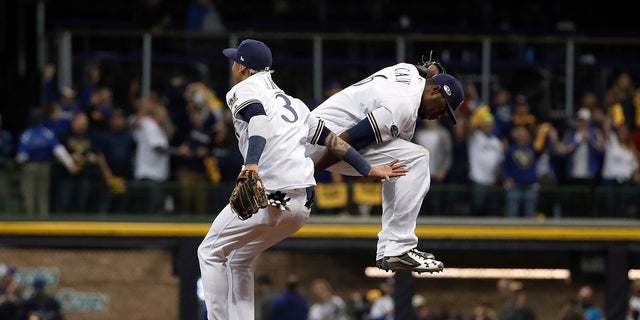 file - Milwaukee Brewers' Orlando Arcia (3) and Lorenzo Cain (6) celebrate after Game 6 of the National League Championship Series baseball game against the Los Angeles Dodgers.
