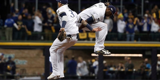 file - Milwaukee Brewers' Orlando Arcia (3) and Lorenzo Cain (6) celebrate after Game 6 of the National League Championship Series baseball game against the Los Angeles Dodgers.