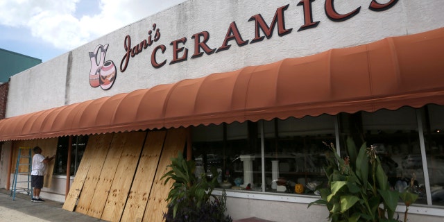 Bobby Smith boards up the windows at Jani's Ceramics in Panama City, Fla., in preparation for the arrival of Hurricane Michael.