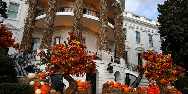 Two girls posing for a photograph with the decorated South Portico of the White House on Sunday.