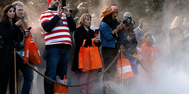 Parents taking photographs of their children in Halloween costumes, as mist from a fog machine rose around them, during a trick-or-treat event with President Donald Trump and first lady Melania Trump at the White House.