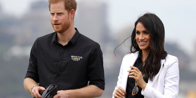 Britain's Prince Harry operates a remote control car with Meghan, Duchess of Sussex at the Invictus Games driving challenge on Cockatoo Island in Sydney, Australia, Saturday, Oct. 20, 2018. Prince Harry and his wife Meghan are on day five of their 16-day tour of Australia and the South Pacific. (AP Photo/Kirsty Wigglesworth)