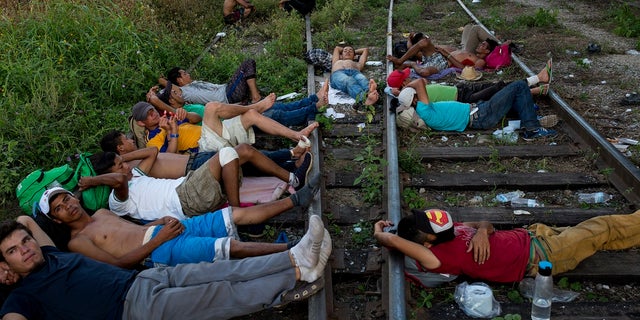 Central American migrants rest on the train tracks where the freight train known as "The Beast" has for decades carried migrants north, as a thousands strong caravan travel on foot and by road stops between Pijijiapan and Arriaga, Chiapas state in Mexico.